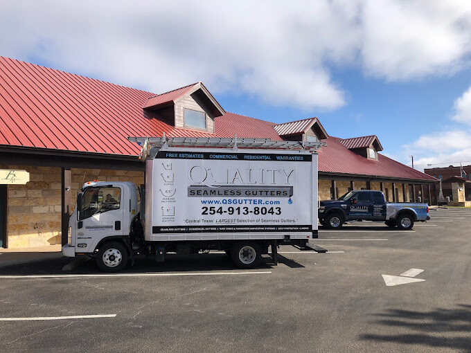 quality seamless gutters trucks parked at business